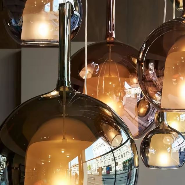 Gros plan sur suspension en verre fumé teinté, allure sculpturale entre design italien et chic contemporain.