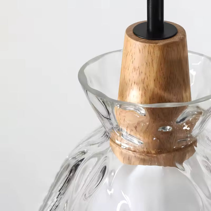 Gros plan sur la finition bois et le verre ondulé d’une suspension au design naturel et artisanal