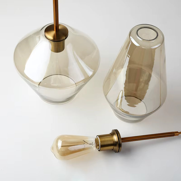 Détails du verre sculptural et des finitions en laiton d’une suspension géométrique au style rétro élégant
