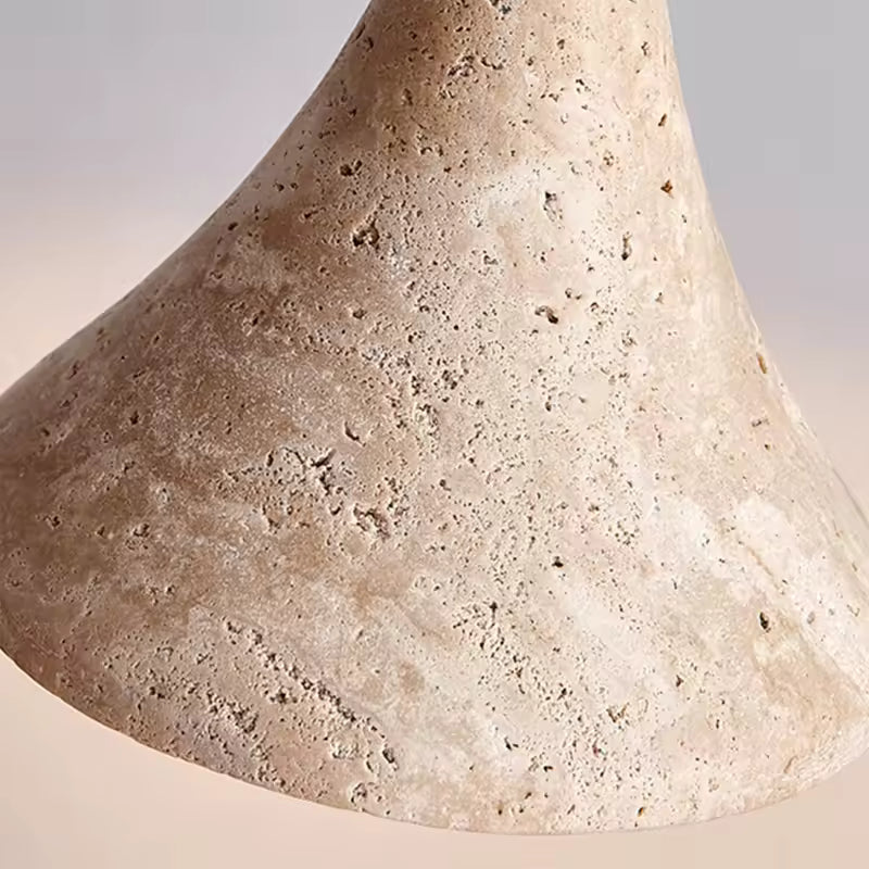 Gros plan sur la texture minérale de la suspension, révélant une pierre claire poreuse au rendu organique et naturel