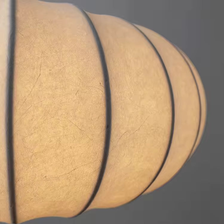 Gros plan sur le tissu ivoire texturé et les nervures de ce luminaire au style japandi chaleureux
