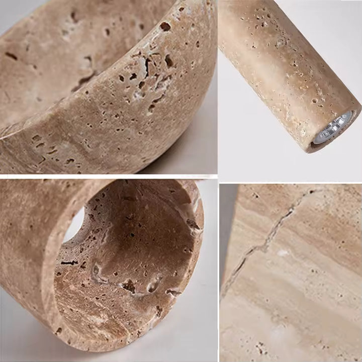 Gros plan sur le travertin naturel texturé d’une suspension tube au design organique et minéral
