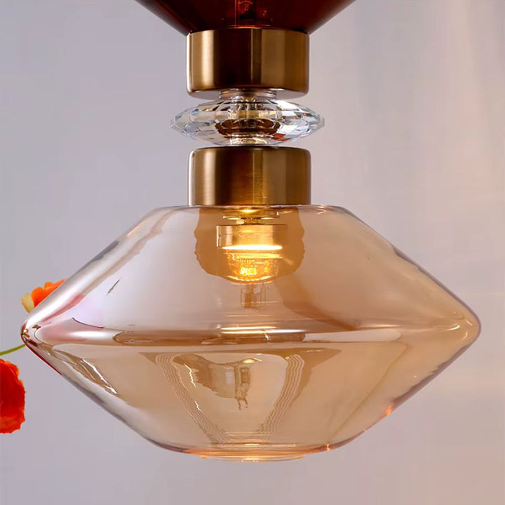 Gros plan sur un élément en verre ambré facetté, souligné de finitions dorées au style Art déco raffiné
