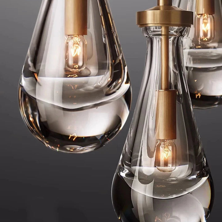 Zoom sur les finitions raffinées en cuivre et le verre sculpté de cette suspension lumineuse goutte d'eau.