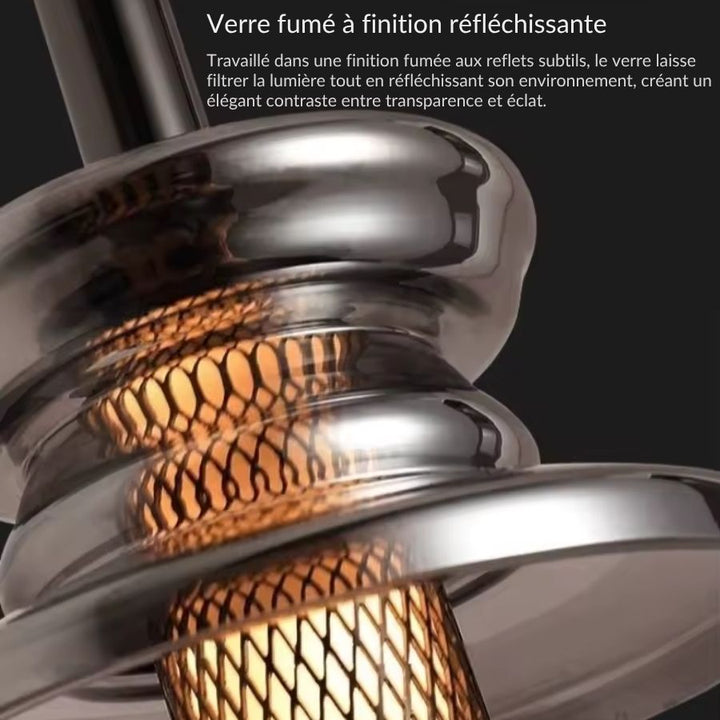 Reflets profonds du verre fumé autour de la trame ajourée, pour un luminaire contemporain à l’allure sophistiquée