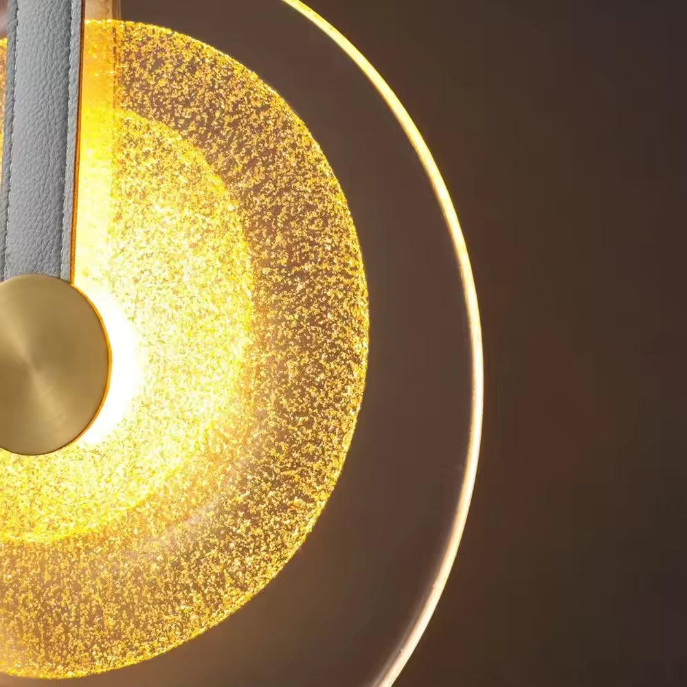 Gros plan sur le verre texturé d’une suspension médaillon, sublimé par une lumière chaude au style luxueux et contemporain