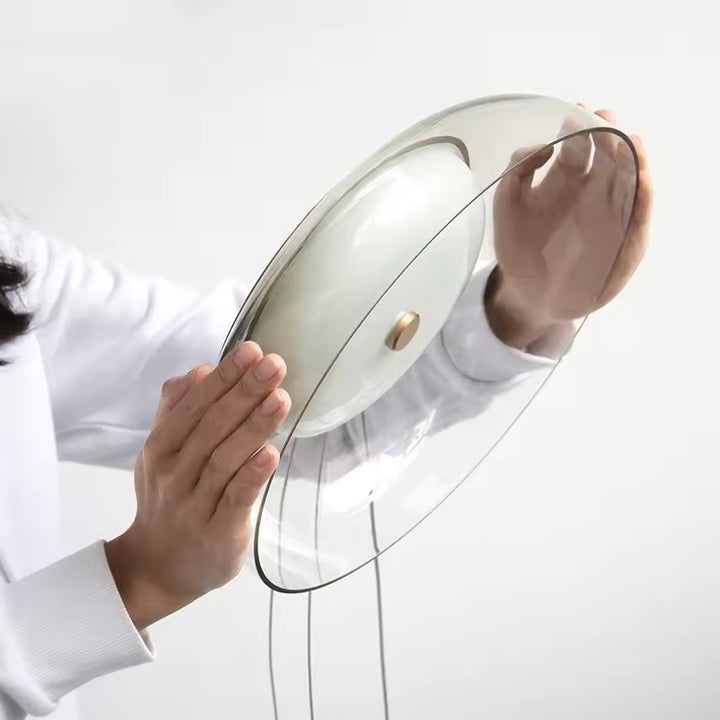 Vue rapprochée du verre transparent et du diffuseur opalin d’une suspension au design épuré et contemporain