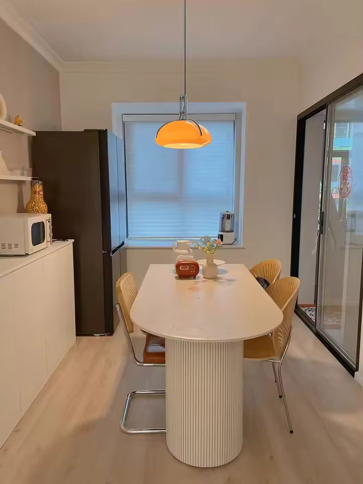 Dôme orange brillant à finitions chromées au-dessus d’une table, dans un intérieur rétro moderne d’inspiration Space Age