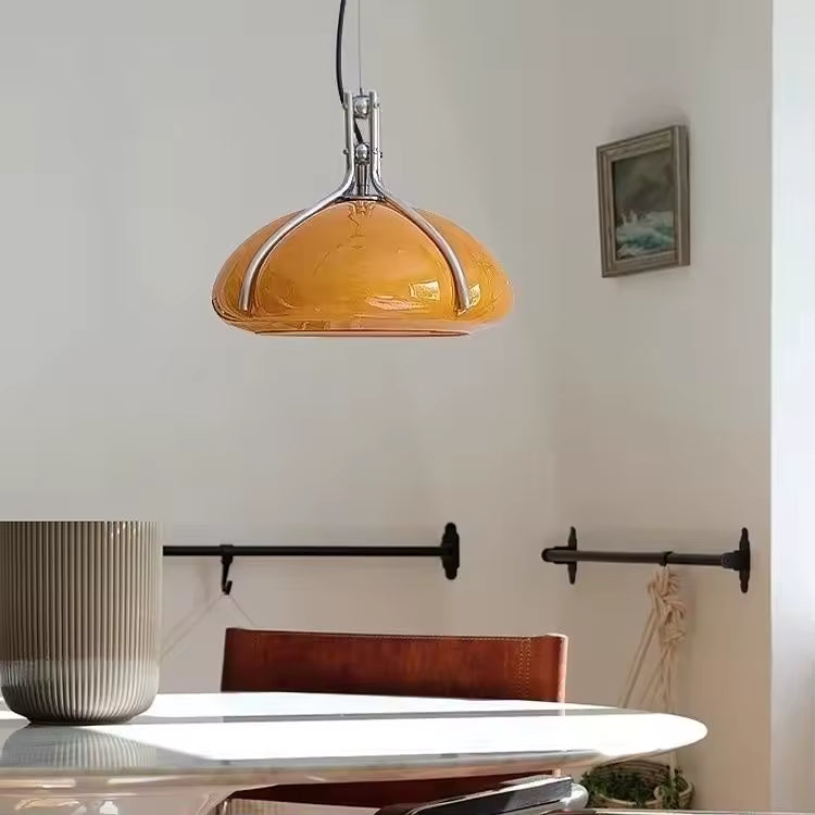 Suspension à dôme orange à structure chromée au-dessus d’une table, dans une salle à manger au style rétro Space Age