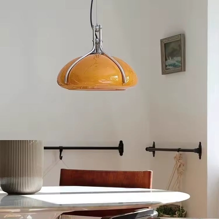 Suspension à dôme orange à structure chromée au-dessus d’une table, dans une salle à manger au style rétro Space Age