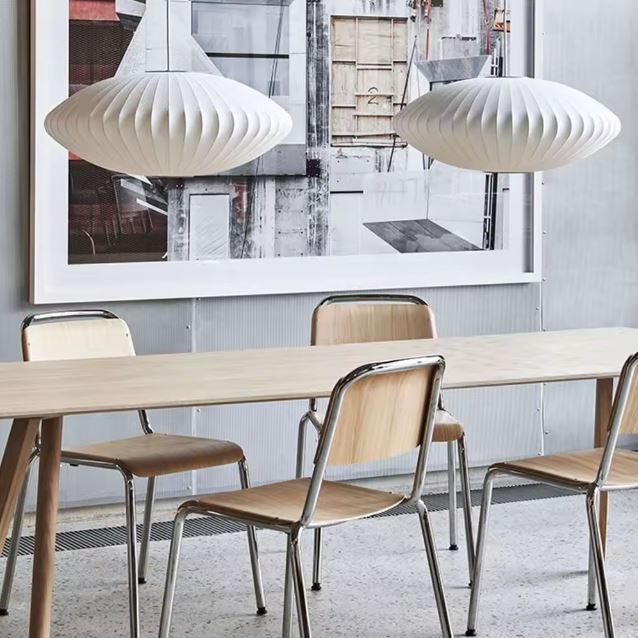 Duo de suspensions blanches côtelées au-dessus d’une table, dans un esprit scandinave, organique et contemporain.