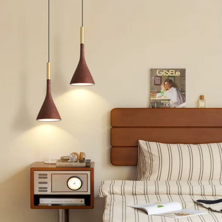 Duo de luminaires coniques effet noyer et laiton dans une chambre chaleureuse aux accents rétro contemporains