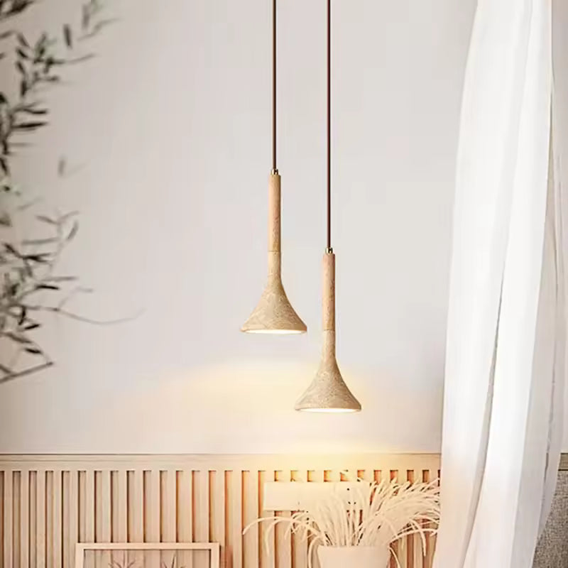Deux suspensions en pierre et bois clair apportent une lumière douce à un intérieur japandi aux lignes minimalistes