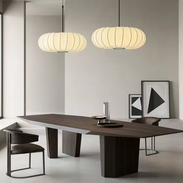 Deux suspensions en tissu ivoire nervuré au-dessus d’une table, dans un intérieur japandi épuré