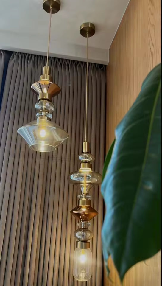 Deux suspensions en verre ambré et transparent aux formes superposées créent une composition verticale au style rétro