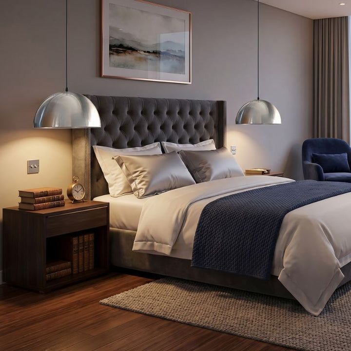 Deux luminaires suspendus chromés diffusant une lumière douce dans une chambre luxueuse.