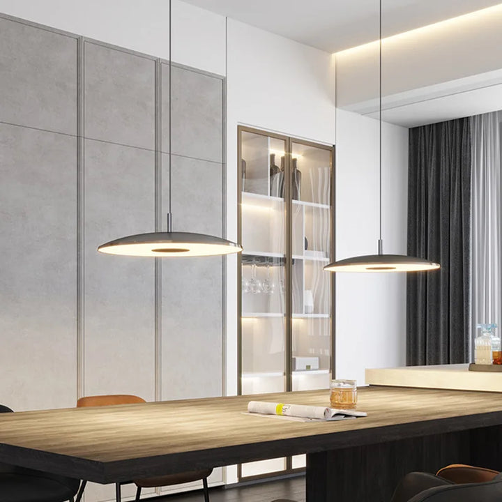 Agencement de luminaires suspendus contemporains valorisant une grande tablée dans un intérieur chic.
