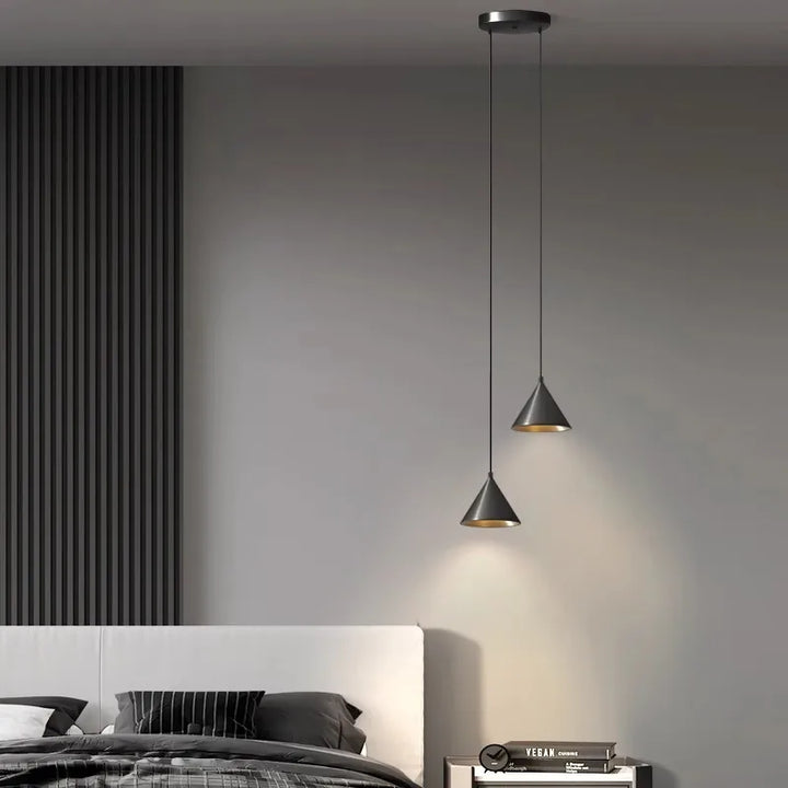 Élégante suspension conique diffusant un éclairage focalisé dans un intérieur au style minimaliste soigné.