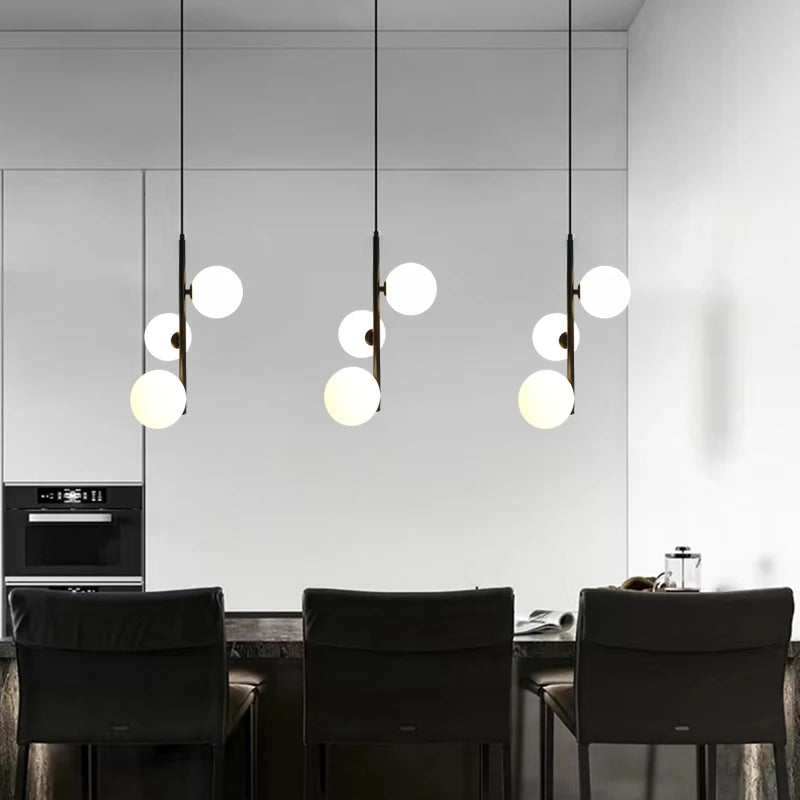 Ensemble de suspensions LED design alignées au-dessus d'une table de salle à manger contemporaine.