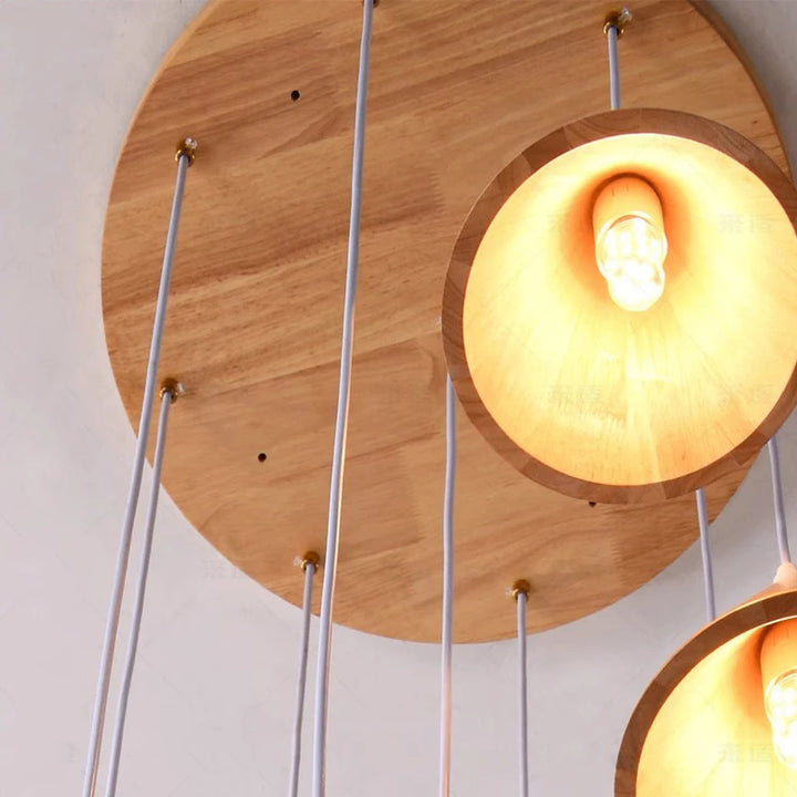 Gros plan sur la base en bois d'une suspension sculpturale, montrant la qualité des finitions du luminaire.