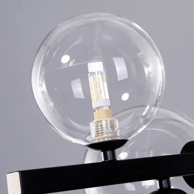 Gros plan sur un globe en verre transparent avec ampoule LED, révélant le détail élégant et moderne de la suspension design contemporaine.