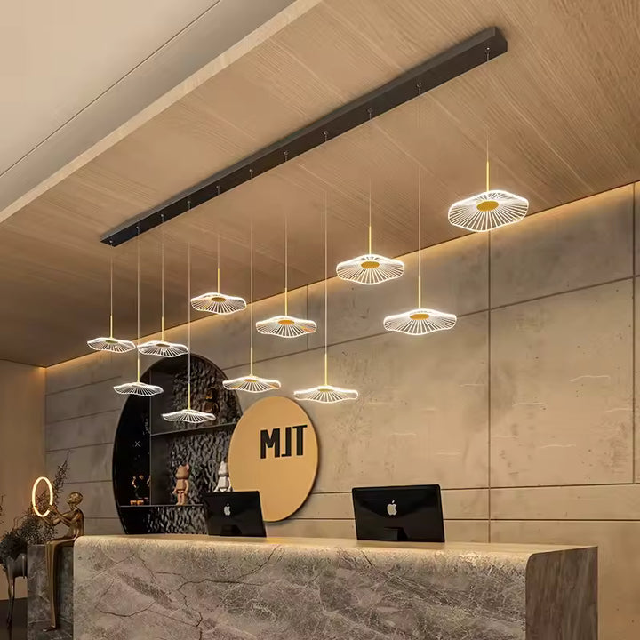 Dans un hall d'accueil moderne, un lustre linéaire noir à 11 ombrelles LED suspendues crée un éclairage graphique et aérien.
