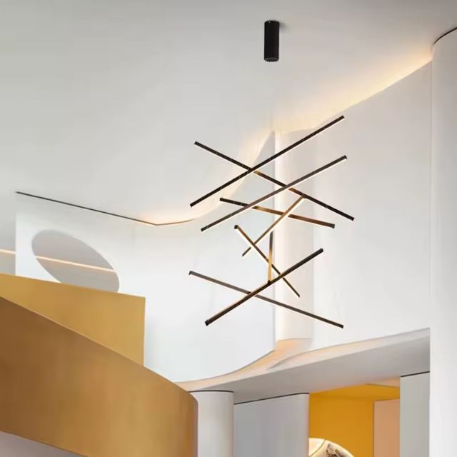 Grande suspension cage d’escalier à lignes LED croisées, parfaite pour une architecture intérieure audacieuse et sculptée.