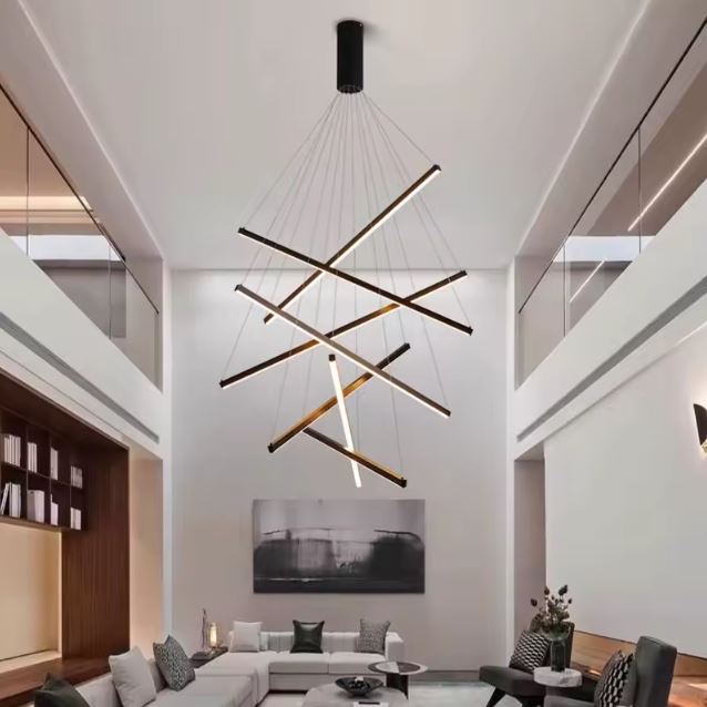 Grande suspension cage d’escalier LED design, suspendue verticalement pour habiller une pièce à double hauteur.