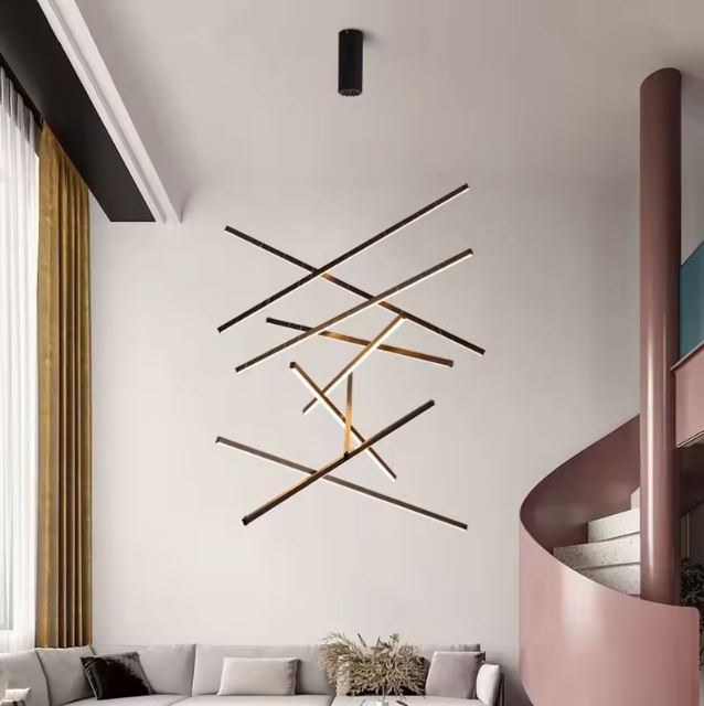 Grande suspension cage d’escalier au design minimaliste, composée de barres LED croisées pour un effet graphique.