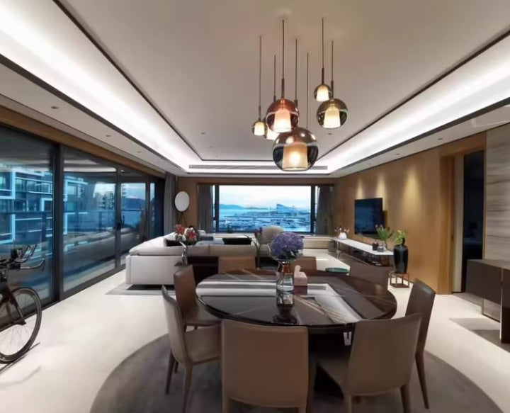 Grande suspension multiple en verre fumé au-dessus d’une salle à manger, style contemporain haut de gamme.
