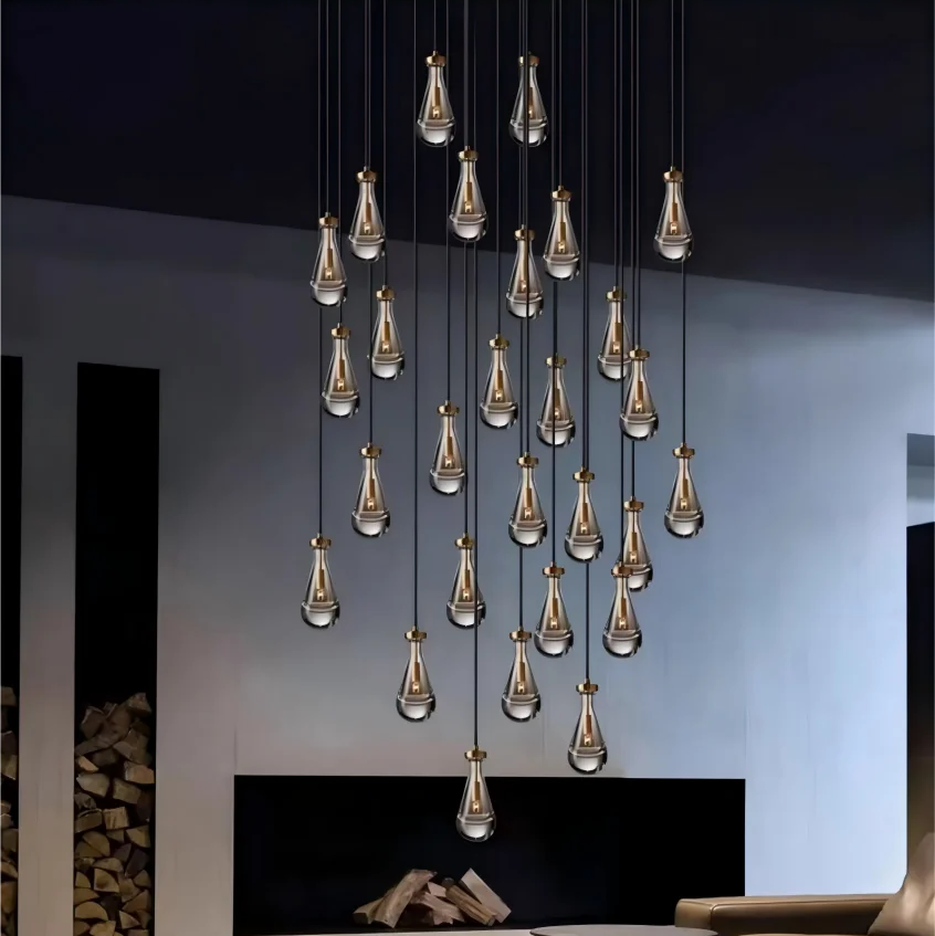 Magnifique grappe lumineuse de gouttes d'eau en verre avec détails en cuivre, créant une ambiance chic et chaleureuse.