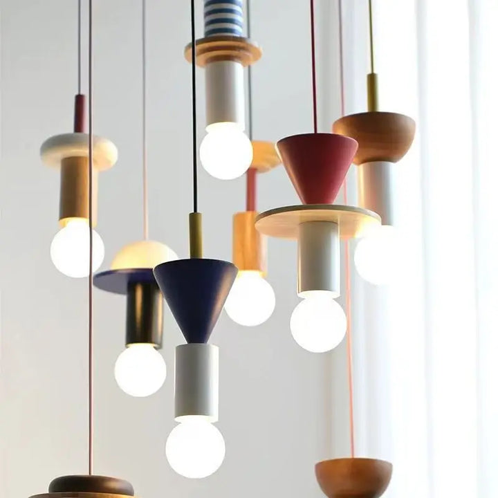 Grappe de suspensions totem géométriques colorées créant un luminaire de plafond original et artistique.