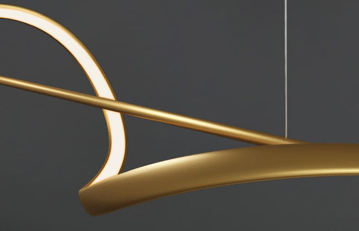 Gros plan sur les finitions métalliques dorées et le ruban ondulé d'un luminaire design haut de gamme.