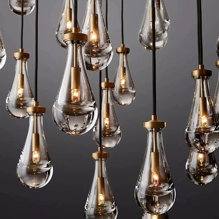 Gros plan sur la texture élégante et le verre transparent d'une suspension en forme de goutte d'eau en cuivre.