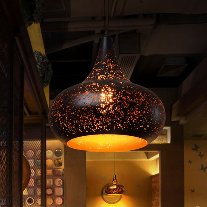 Gros plan artistique d'une suspension constellation perforée en métal allumée, esprit Art Déco.