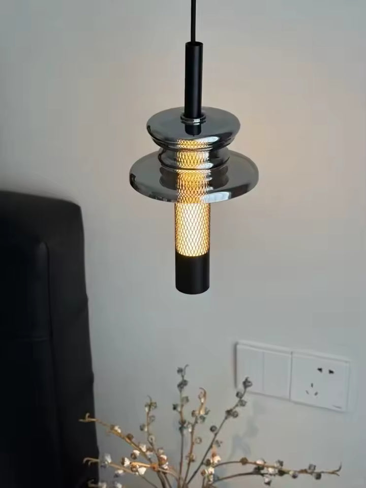 Vue rapprochée d’un luminaire en verre fumé et aluminium ajouré, à l’allure industrielle et contemporaine