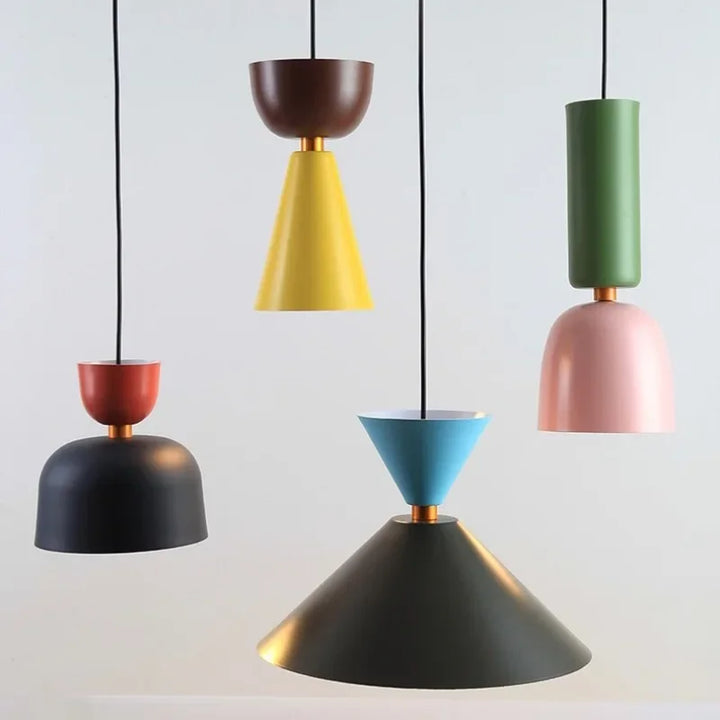 Gros plan sur un groupe de luminaires suspendus au style Bauhaus, combinant formes géométriques et teintes vitaminées.