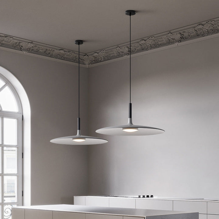 Îlot central de cuisine moderne avec suspension UFO en métal gris au design industriel.