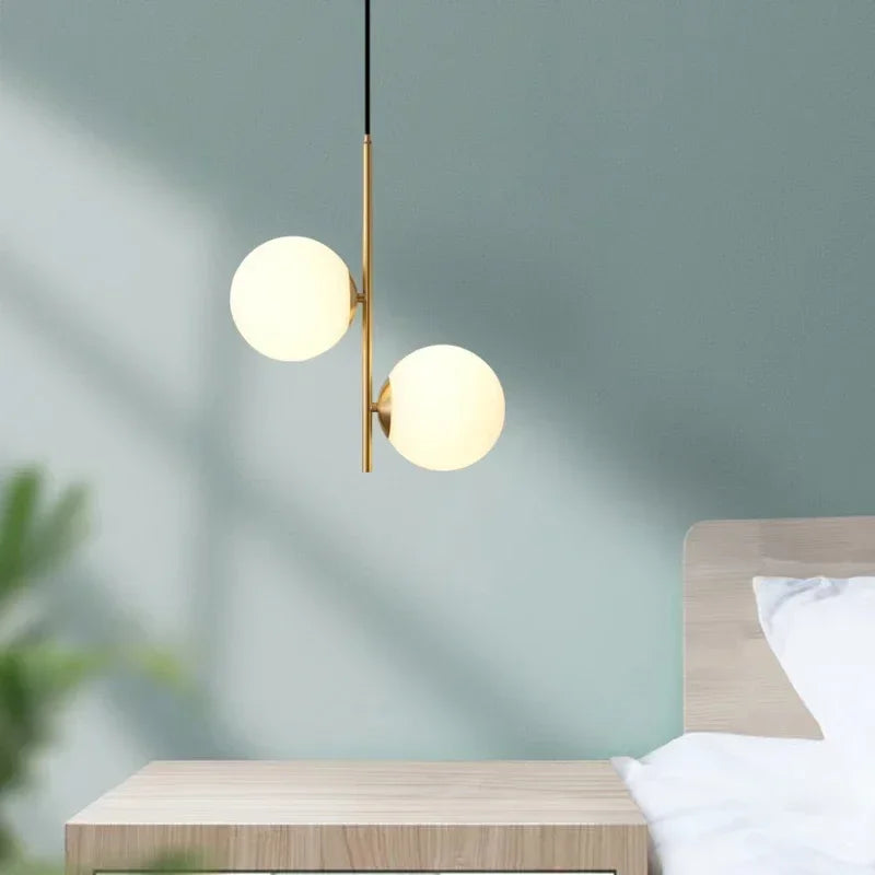 Lampe pendant moderne avec finitions dorées et sphères lumineuses, parfait pour une décoration épurée.