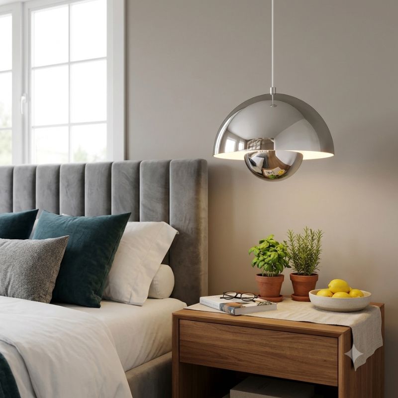 Élégante lampe de plafond style scandinave chromée surplombant une table de chevet en bois moderne.