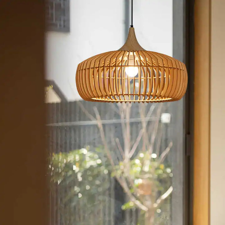 Abat-jour suspendu en bois ajouré créant des jeux d'ombre et de lumière dans une pièce cosy.