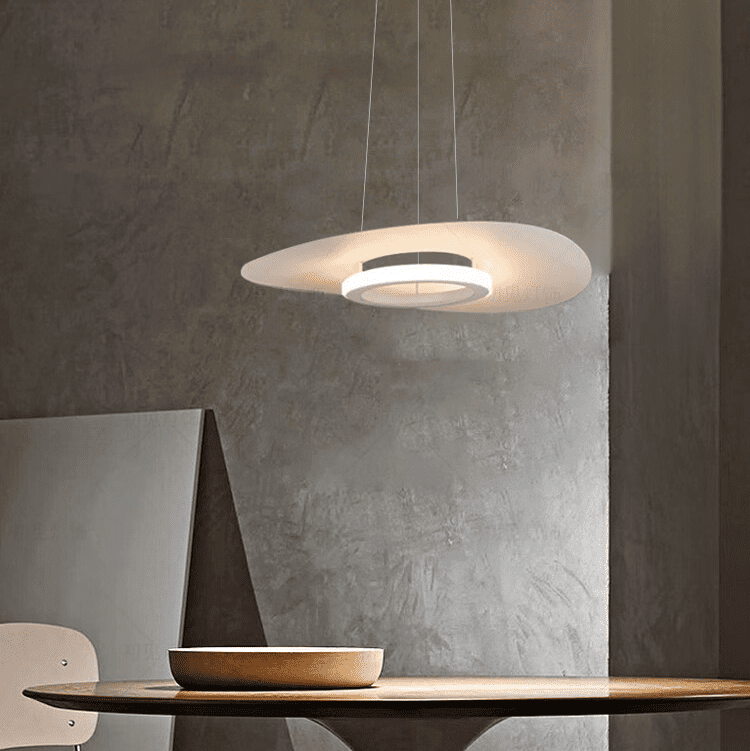 Lampe suspendue disque flottant diffusant une douce lumière dans un intérieur brut.