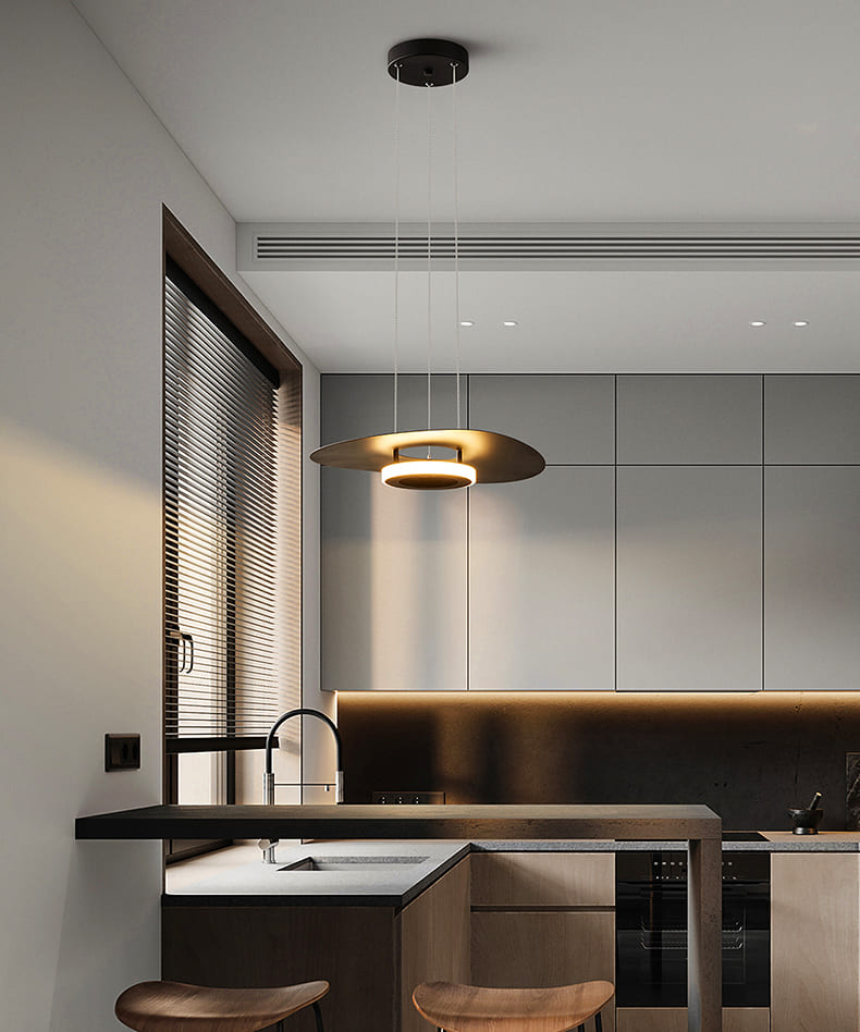 Lampe suspendue disque flottant minimaliste éclairant un îlot de cuisine contemporain.