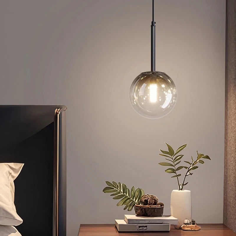 Gros plan sur une élégante lampe suspendue en verre aux reflets chaleureux dans un coin salon.
