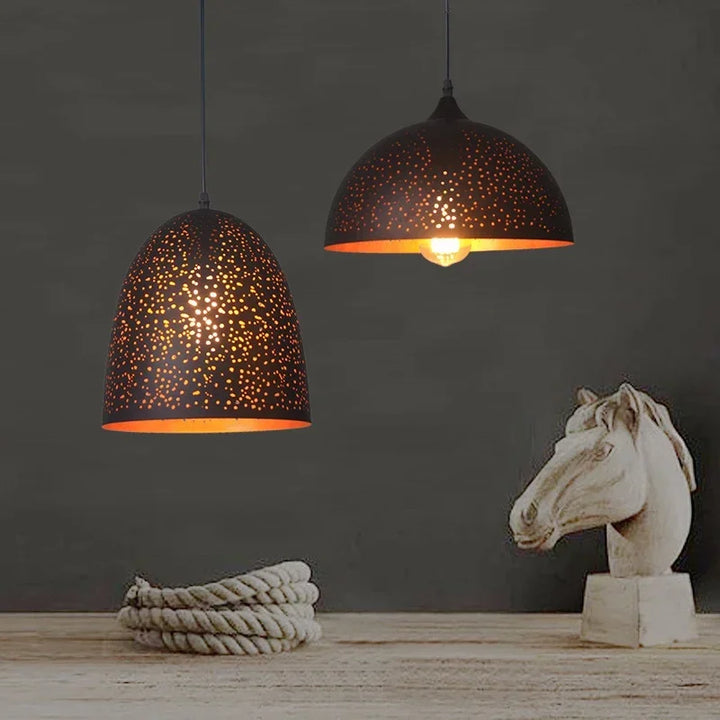 Suspension constellation perforée en métal noir installée sur un meuble en bois, style déco contemporaine.