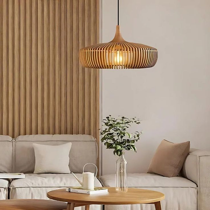 Luminaire suspendu en bois clair intégré dans un salon moderne aux teintes neutres.
