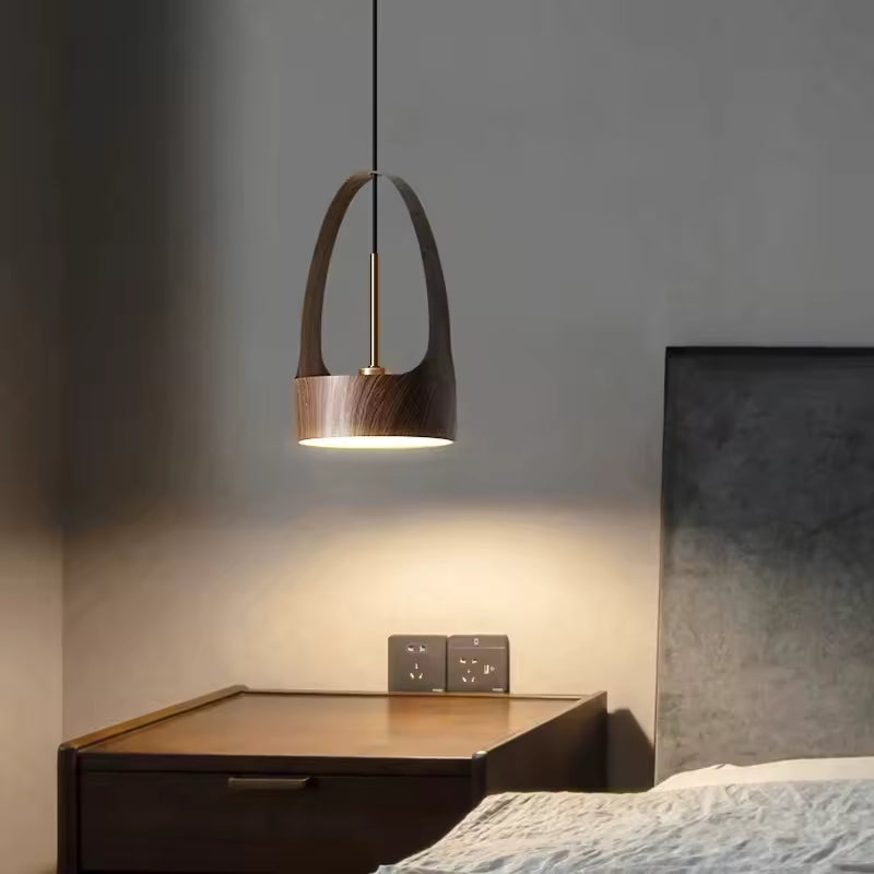 Près du lit, ce luminaire à arche métallique effet bois diffuse une lumière douce dans une chambre contemporaine