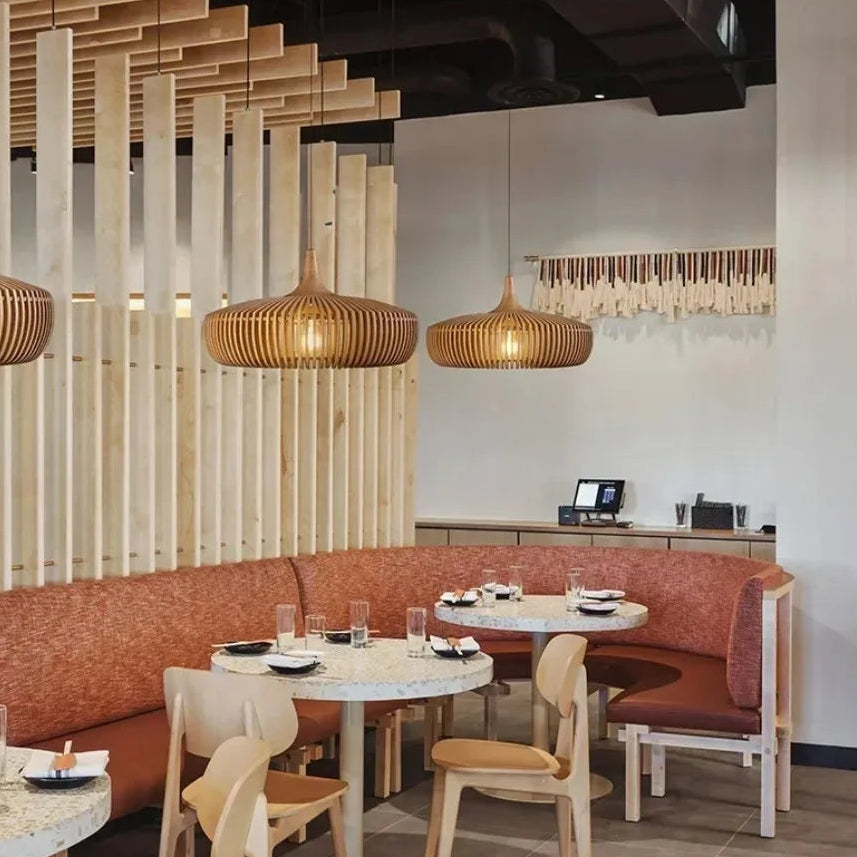 Suspensions en bois ajouré créant une ambiance conviviale dans un espace de restauration.