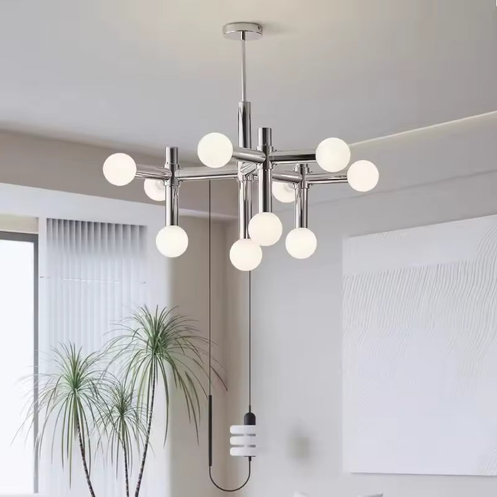 Luminaire chromé à globes opalins lumineux, au design géométrique contemporain dans un salon épuré