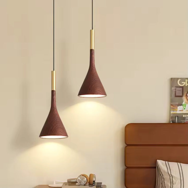 Près du lit, le luminaire conique effet noyer et laiton apporte une touche chaleureuse au décor contemporain